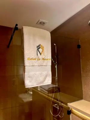 a towel with the words moloko is marina hanging in a bathroom at Hôtel Le Manoir in Taza