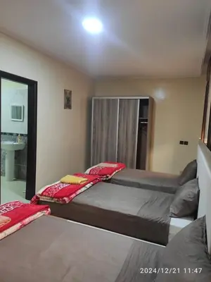 a bedroom with two beds and a mirror at Welcome Hôtel Dijon in Ouzoud