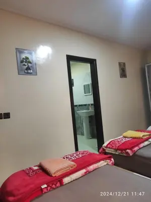 a room with two beds and a mirror in it at Welcome Hôtel Dijon in Ouzoud