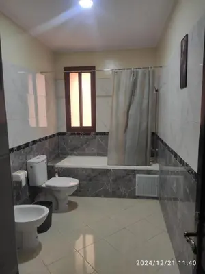 a bathroom with two toilets and a bath tub at Welcome Hôtel Dijon in Ouzoud