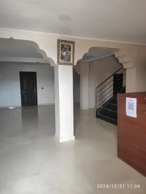 a large room with a staircase and a picture on the wall at Welcome Hôtel Dijon in Ouzoud
