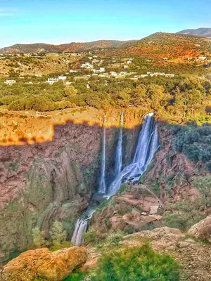 a waterfall on the side of a mountain at Welcome Hôtel Dijon in Ouzoud