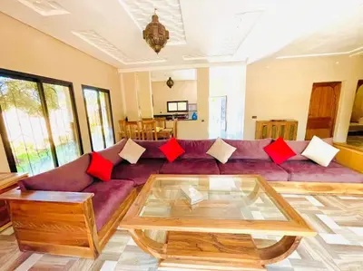 a living room with a purple couch with red pillows at Villa des tortues 3 Marrakech piscine chaufée privative sans vis à vis in Marrakech