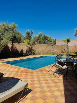 a patio with a table and chairs next to a pool at Villa des tortues 3 Marrakech piscine chaufée privative sans vis à vis in Marrakech