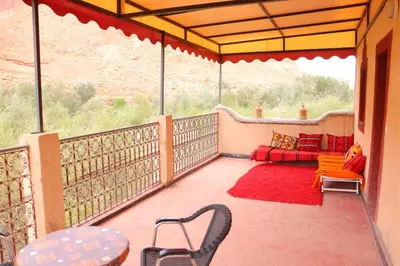 a balcony with a couch and a table and chairs at Gite d'étape Tafsoute in Tameskikt