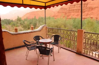 a table and chairs on a balcony with a view at Gite d'étape Tafsoute in Tameskikt