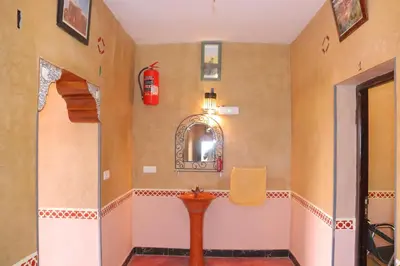 a bathroom with a sink and a fire extinguisher on the wall at Gite d'étape Tafsoute in Tameskikt
