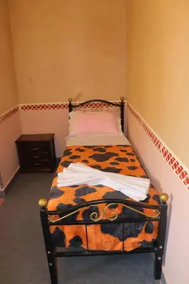 a small bed in a corner of a room at Gite d'étape Tafsoute in Tameskikt