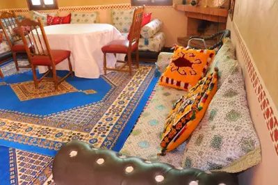 a living room with a table and chairs and a couch at Gite d'étape Tafsoute in Tameskikt