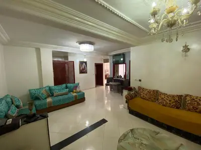 a large living room with couches and a chandelier at apartement moderne fes in Fès