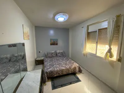 a bedroom with a bed and a window at apartement moderne fes in Fès