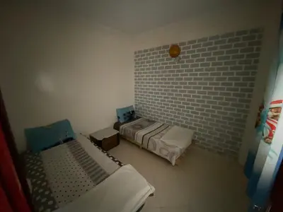 a room with two beds and a brick wall at apartement moderne fes in Fès