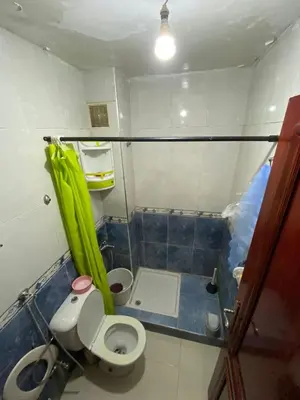 a bathroom with a toilet and a green umbrella at apartement moderne fes in Fès