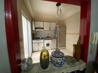 a small kitchen with a table with vases on it at apartement moderne fes in Fès