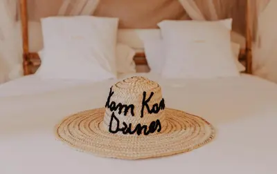 a straw hat sitting on top of a bed at Kam Kam Dunes in Merzouga