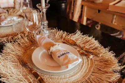 a table with a plate of food and wine glasses at Kam Kam Dunes in Merzouga