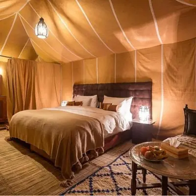 a bedroom with a bed in a tent at desert tribe luxury camp in Merzouga