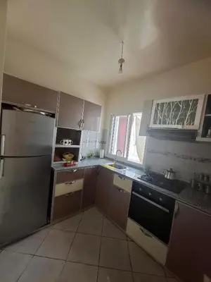 a kitchen with a refrigerator and a stove top oven at Appartement à côté de Kitea route de Sefrou in Fès