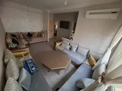 a living room with a blue couch and a table at Appartement à côté de Kitea route de Sefrou in Fès