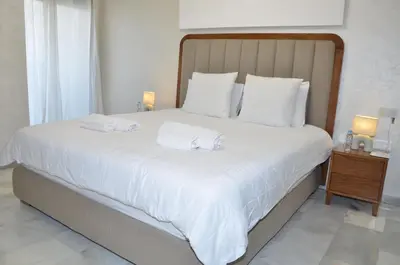 a bedroom with a large bed with white sheets and pillows at Miramar Prestigia in Ville Nouvelle