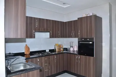 a kitchen with wooden cabinets and a sink and a counter at Miramar Prestigia in Ville Nouvelle
