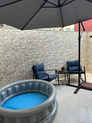 a large umbrella over a hot tub with chairs and a table at Miramar Prestigia in Ville Nouvelle