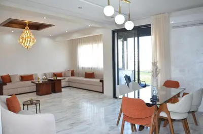 a living room with a couch and a table and chairs at Miramar Prestigia in Ville Nouvelle