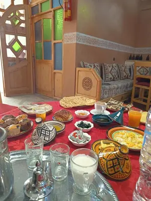 a table with plates of food on a red table cloth at Riad Restaurant MARZOUK in Aït Baha