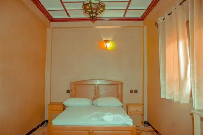 a bedroom with a bed with a light on the ceiling at Riad Restaurant MARZOUK in Aït Baha