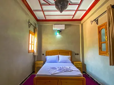 a bedroom with a bed with a ceiling at Riad Restaurant MARZOUK in Aït Baha