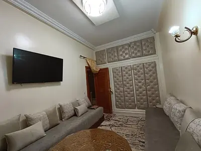 a living room with a couch and a flat screen tv at Appartement a Meknès-Hamria in Meknès