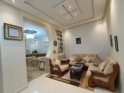 a living room with a couch and chairs and a table at Appartement a Meknès-Hamria in Meknès