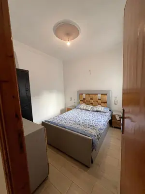 a bedroom with a bed with a blue comforter at Modern apartment Hamria Meknes in Meknès
