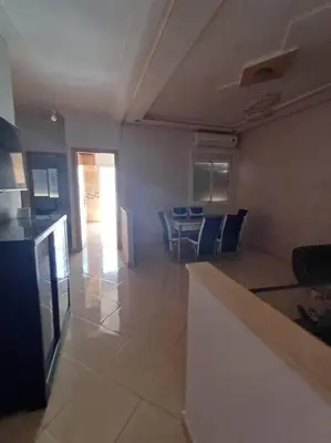 a kitchen and living room with a table and chairs at Modern apartment Hamria Meknes in Meknès