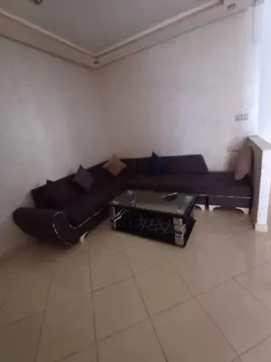 a living room with a black couch and a coffee table at Modern apartment Hamria Meknes in Meknès