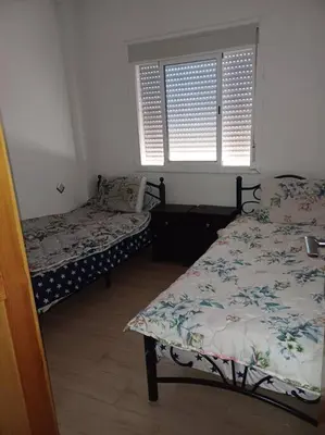 a bedroom with two beds and a window at Modern apartment Hamria Meknes in Meknès