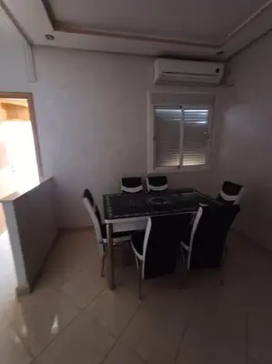 a dining room with a table and chairs and a window at Modern apartment Hamria Meknes in Meknès