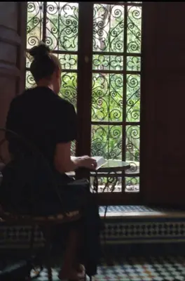 a woman sitting in a chair in front of a window at زاوية السعادة in Fès