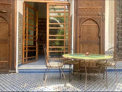 a table and chairs sitting in front of a door at زاوية السعادة in Fès