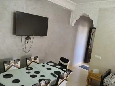 a living room with a table and a flat screen tv at maison soleil in Ifrane
