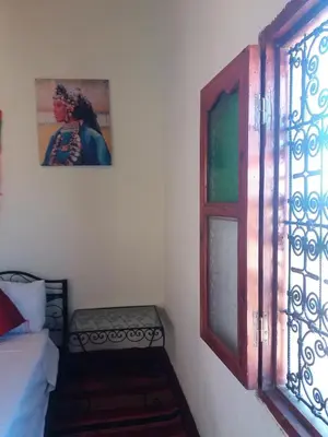 a bedroom with a bed and a window and a picture at Kasbah Les Nomades in Skoura