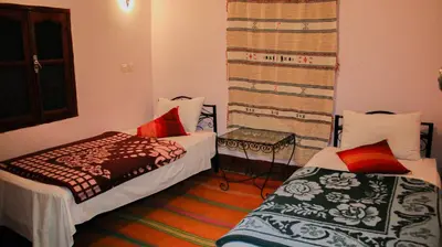 a hotel room with two beds and a table at Kasbah Les Nomades in Skoura