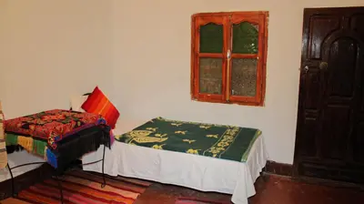 a bedroom with a small bed and a window at Kasbah Les Nomades in Skoura