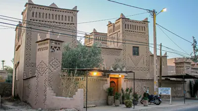 a building with a motorcycle parked in front of it at Kasbah Les Nomades in Skoura