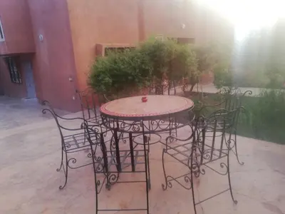 an iron table and chairs in a courtyard at Dâr Mâbâ in Tazenakht