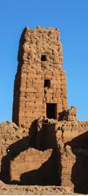 an old brick tower with a blue sky in the background at Dâr Mâbâ in Tazenakht
