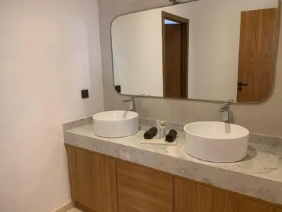 a bathroom with two sinks and a large mirror at Villa de standing piscine à débordement à 15 min de Marrakech in Ourika