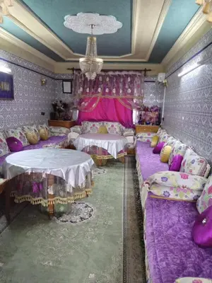 a room with couches and tables and purple walls at إقامة شاكر in Meknès