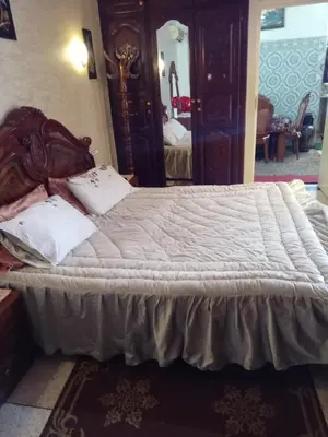 a bedroom with a large bed with white sheets at إقامة شاكر in Meknès