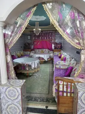 a room with two beds and two tables at إقامة شاكر in Meknès
